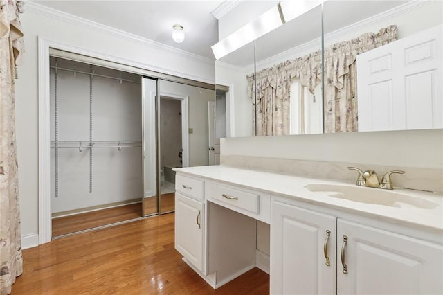 bathroom with hardwood / wood-style floors, vanity, and ornamental molding