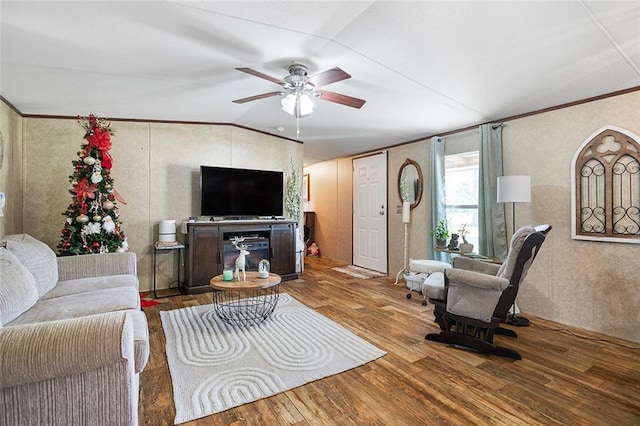 living room with lofted ceiling, ceiling fan, wood-type flooring, and crown molding