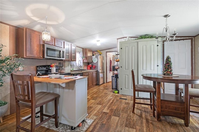 kitchen featuring hanging light fixtures, sink, hardwood / wood-style flooring, appliances with stainless steel finishes, and a notable chandelier