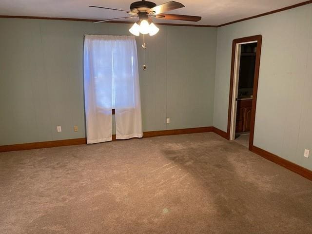 carpeted empty room with ceiling fan and ornamental molding