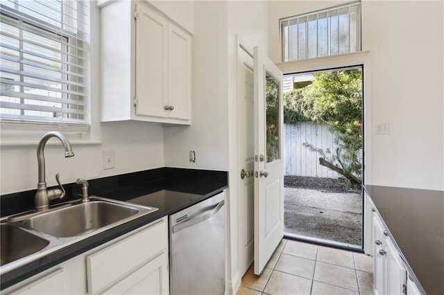 kitchen featuring dishwasher, light tile patterned floors, white cabinets, and sink