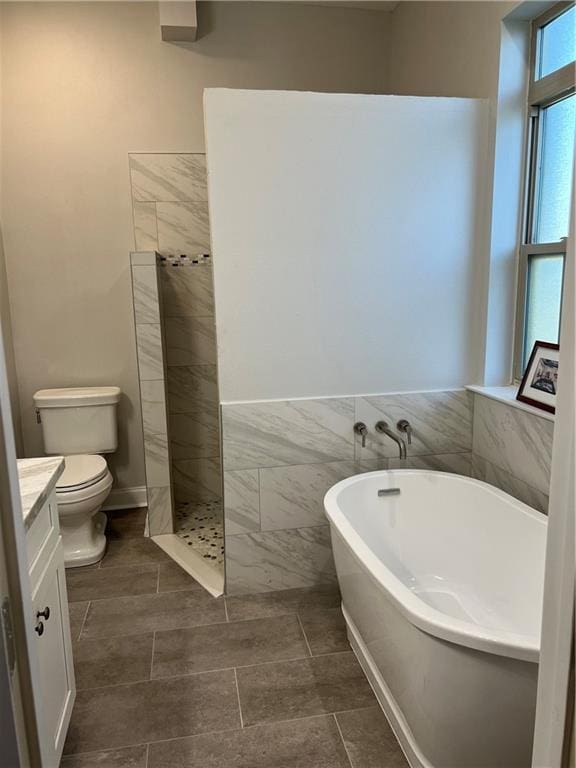 full bathroom featuring vanity, toilet, tile walls, and plus walk in shower