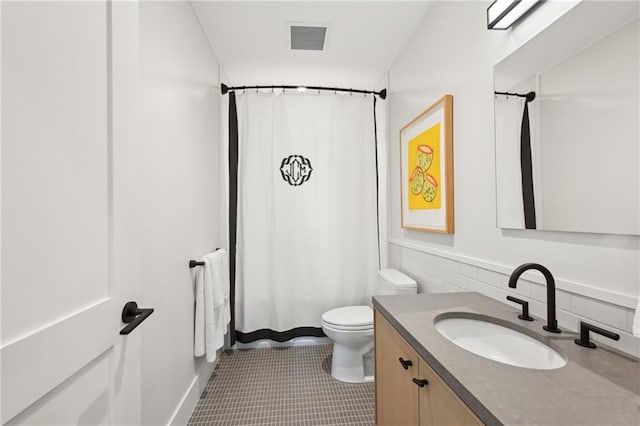 bathroom with tile patterned floors, walk in shower, vanity, and toilet