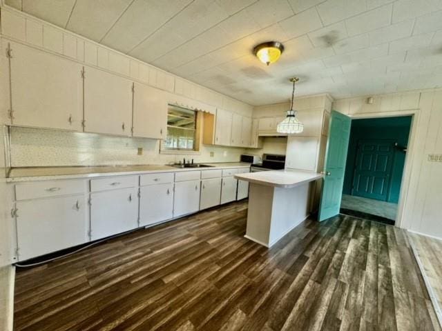 kitchen featuring sink, white cabinetry, hanging light fixtures, and electric stove