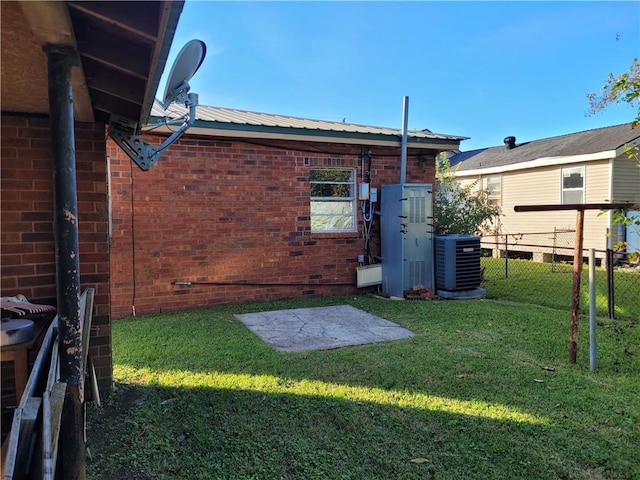 rear view of property featuring cooling unit and a yard