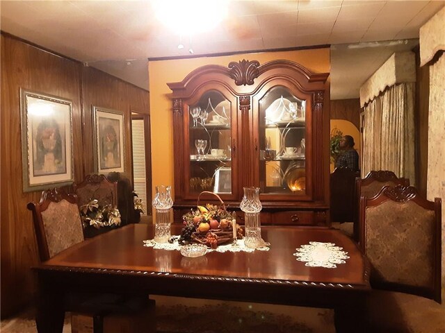 dining space featuring wood walls