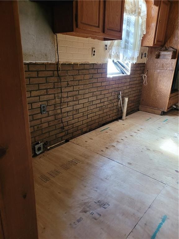 kitchen with light stone countertops and brick wall