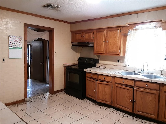 kitchen with a textured ceiling, tile counters, black / electric stove, sink, and crown molding