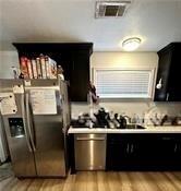 kitchen with stainless steel refrigerator with ice dispenser, light hardwood / wood-style floors, and range hood