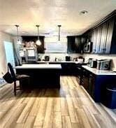 kitchen with hardwood / wood-style flooring, decorative light fixtures, and a kitchen breakfast bar