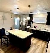 kitchen featuring hanging light fixtures, a kitchen breakfast bar, light hardwood / wood-style floors, and a center island