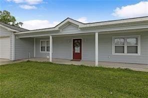 view of front of home with a garage, a front yard, and covered porch