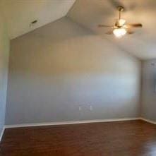 additional living space featuring dark wood-type flooring, vaulted ceiling, and ceiling fan