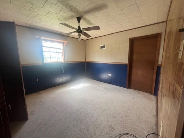 119 Crestwood Dr, Houma, LA 70364 - empty room featuring carpet floors, ceiling fan, and wood walls