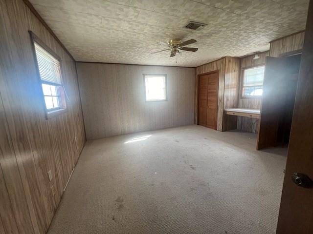 119 Crestwood Dr, Houma, LA 70364 - spare room with ceiling fan, wood walls, and light colored carpet