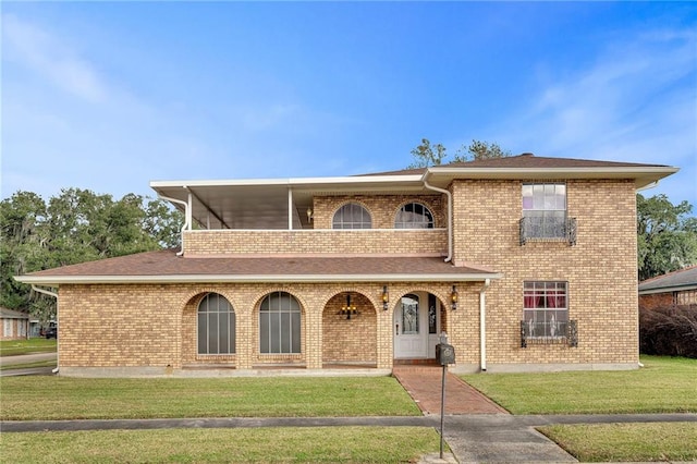 view of front of home with a front yard and a balcony