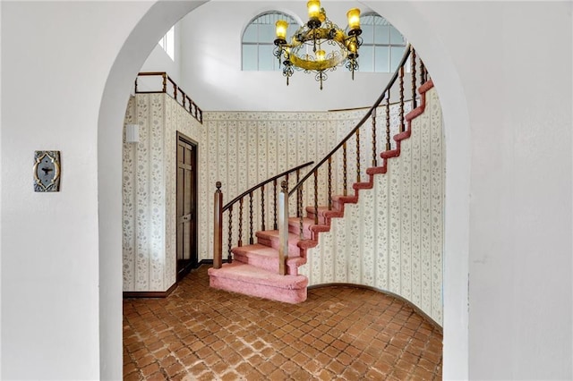 staircase featuring a notable chandelier