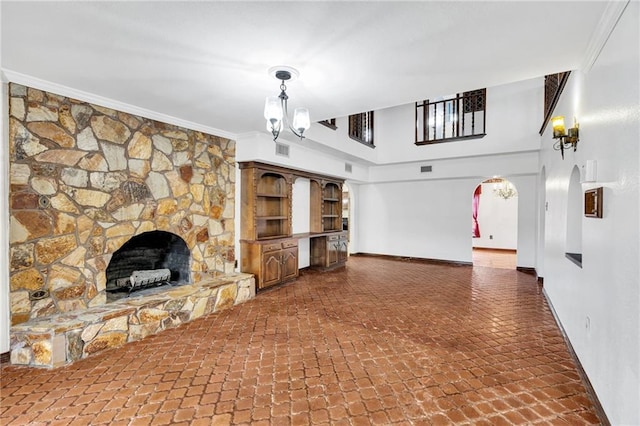 unfurnished living room featuring a notable chandelier, ornamental molding, and a fireplace