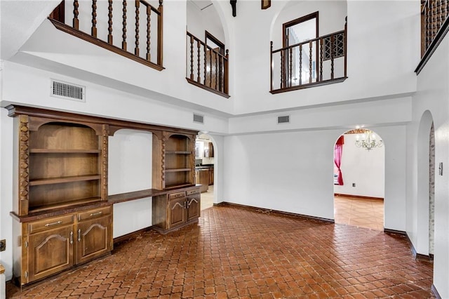 living room with a towering ceiling and a chandelier