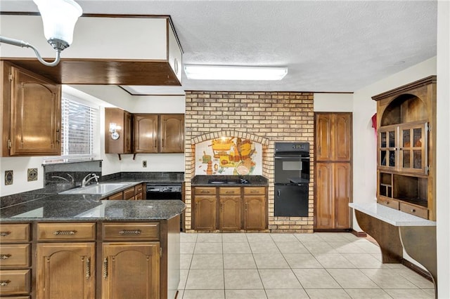 kitchen with kitchen peninsula, black double oven, light tile patterned flooring, and a textured ceiling