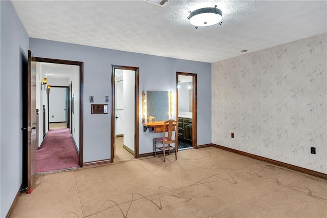 unfurnished bedroom featuring a textured ceiling and ensuite bathroom