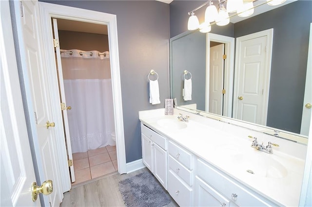 bathroom with hardwood / wood-style floors, vanity, and curtained shower