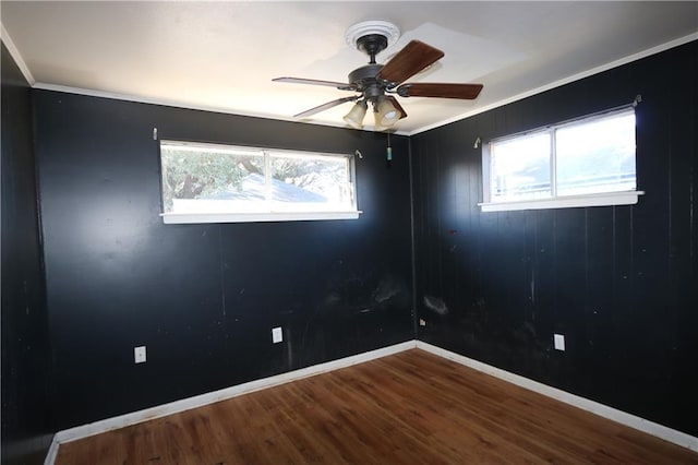 spare room featuring hardwood / wood-style flooring, ceiling fan, a healthy amount of sunlight, and ornamental molding