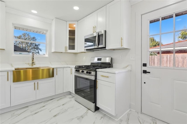 kitchen with white cabinets, appliances with stainless steel finishes, a wealth of natural light, and sink