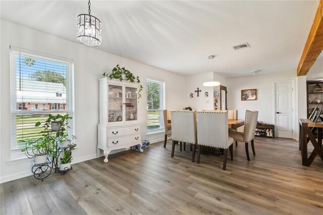 living room with lofted ceiling with beams, light wood-type flooring, a tile fireplace, and ceiling fan