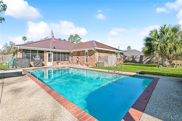 view of pool featuring a patio area, a yard, and a sunroom