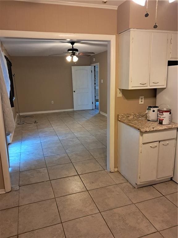 kitchen featuring white cabinets, ceiling fan, white fridge, and light tile patterned floors