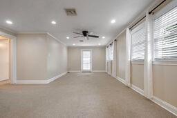 carpeted spare room featuring crown molding, ceiling fan, and a healthy amount of sunlight