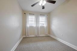 empty room with ceiling fan and light colored carpet