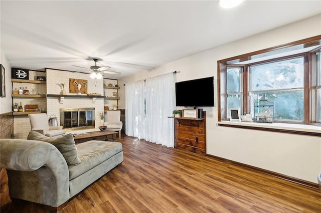 living room featuring ceiling fan, a fireplace, and wood-type flooring