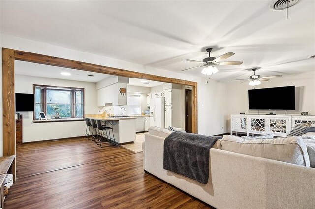 living room featuring wooden walls, a fireplace, ceiling fan, and wood-type flooring