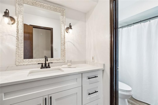 bathroom with hardwood / wood-style flooring, vanity, and toilet