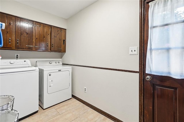 clothes washing area featuring cabinets and independent washer and dryer