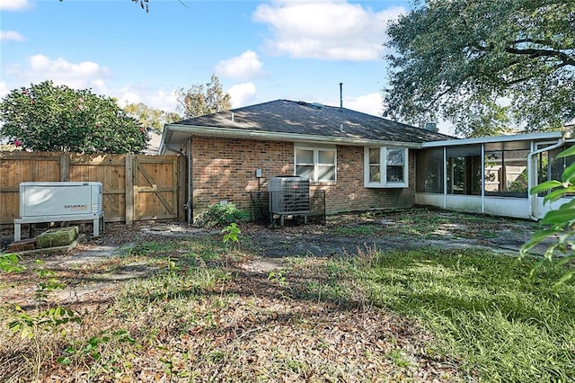 rear view of house with a sunroom and central AC