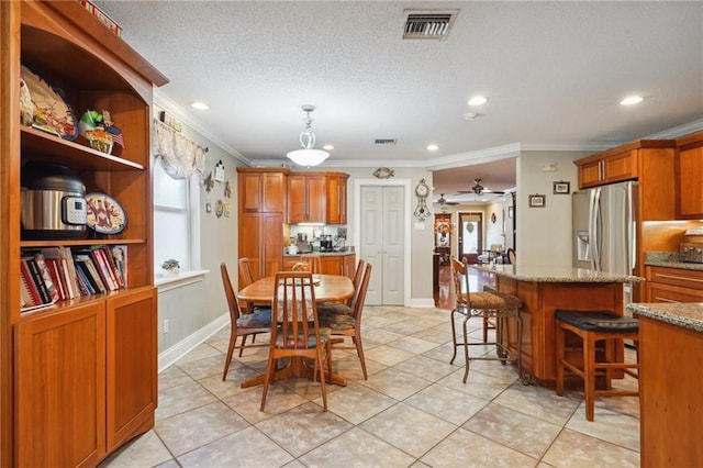 dining area with a textured ceiling, ceiling fan, light tile patterned floors, and crown molding