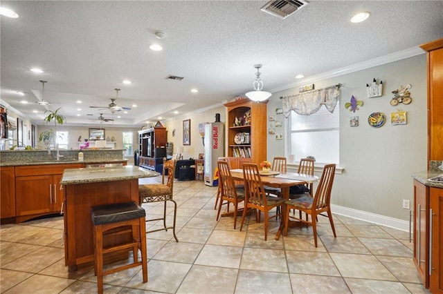 dining room with sink, light tile patterned flooring, and ornamental molding