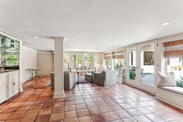 unfurnished living room featuring light tile patterned floors and sink