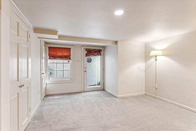 spare room with light colored carpet and crown molding