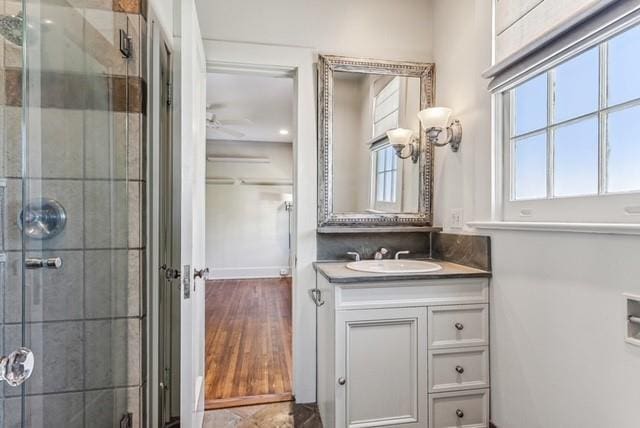 bathroom featuring vanity, ceiling fan, and walk in shower