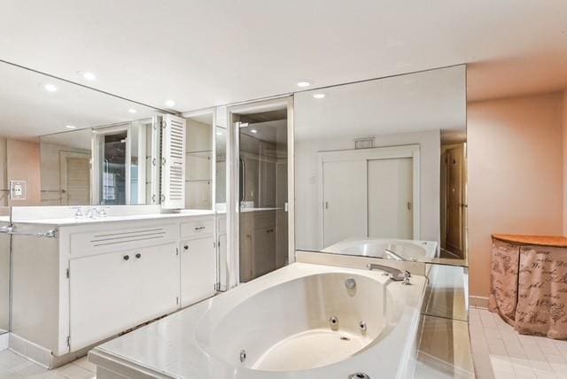 bathroom with a bathing tub, tile patterned flooring, and vanity