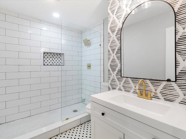 bathroom featuring tiled shower, vanity, and toilet