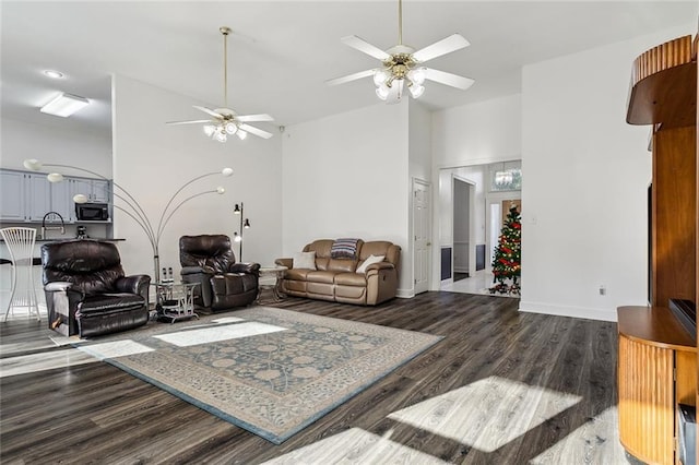 living room featuring ceiling fan, dark hardwood / wood-style flooring, and sink