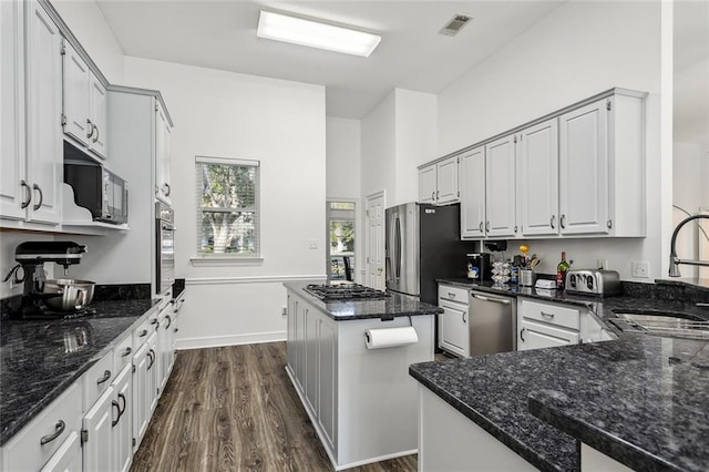 kitchen with dark stone countertops, white cabinetry, and stainless steel appliances