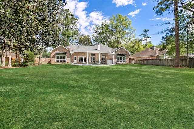 rear view of house featuring a lawn