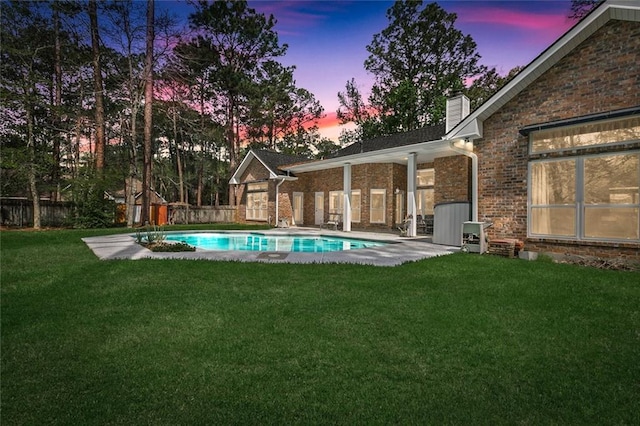 pool at dusk with a lawn