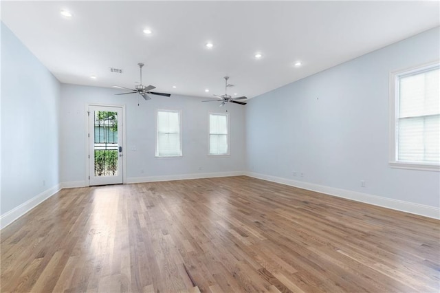 empty room with ceiling fan and light hardwood / wood-style floors